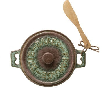 Decorative metal bell with 'Brie Baker Fromage' text on a white background