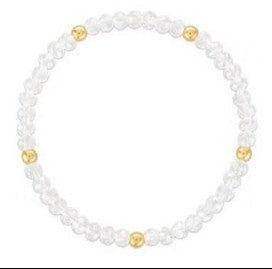 A beaded stretch bracelet featuring small clear faceted beads and five evenly spaced gold round spacer beads, shown on a plain white background.