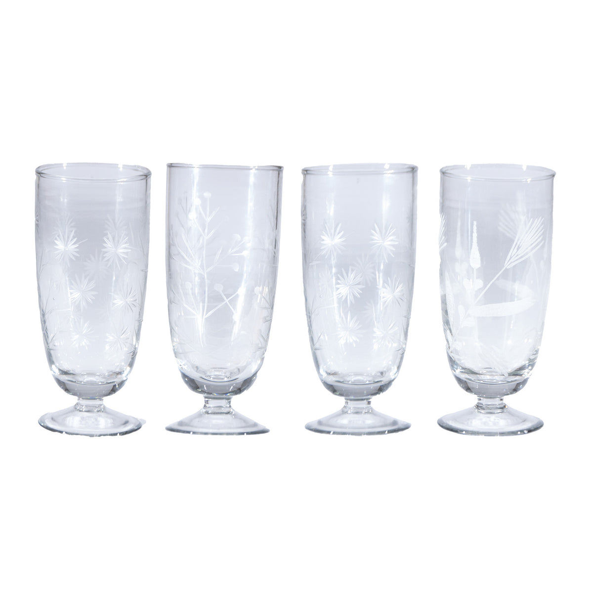 Set of four clear glass tumblers with starburst patterns on a white background