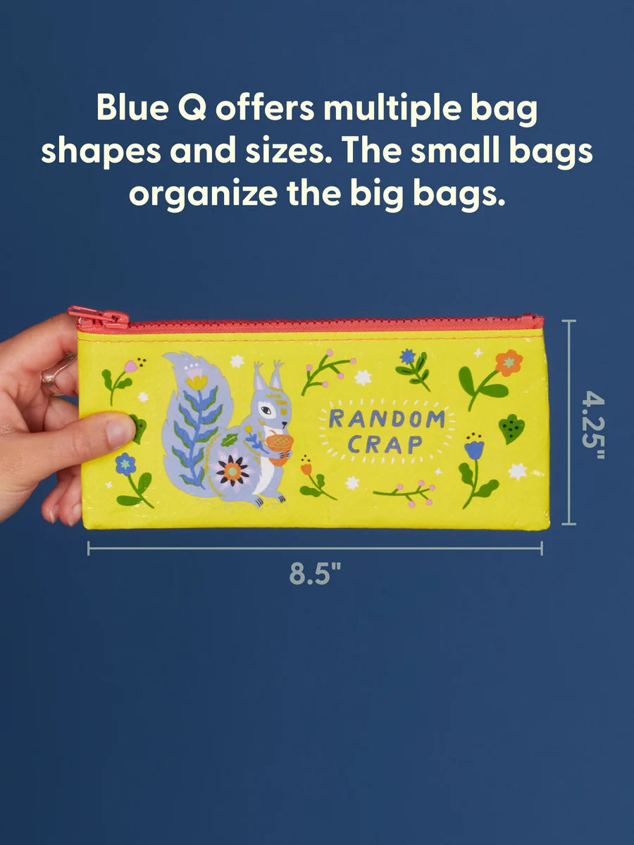 A hand holds a bright yellow zip pouch with a colorful squirrel illustration and the words 'RANDOM CRAP' against a dark blue background. White text at the top says Blue Q offers multiple bag shapes and sizes.