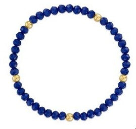 A beaded stretch bracelet featuring deep blue lapis lazuli stones separated by small gold spacer beads, shown against a plain white background.