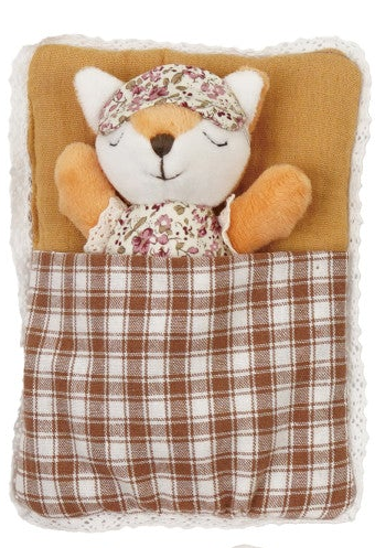A plush fox sleeping in a quilted blanket pouch. The toy features a cream-colored face and paws, orange-brown fur details, a floral-patterned bonnet, and is nestled inside a brown and white plaid blanket with a mustard yellow lining, all framed by a white lace border.