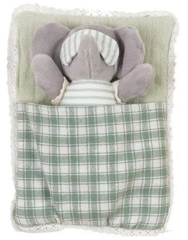 A plush elephant toy tucked inside a soft pillow with a green and white plaid blanket, photographed on a plain white background.
