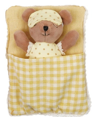 A plush teddy bear wearing a yellow polka-dot sleep cap and matching top, tucked inside a yellow and white gingham blanket pouch on a white background.