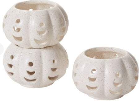 Stackable ceramic pumpkin votive holders with crescent cutouts and warm white speckled glaze, designed for autumn and Halloween décor.