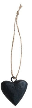 Black heart-shaped ornament hanging on a string against a white background