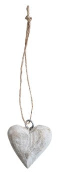Decorative heart-shaped ornament hanging on a string against a white background