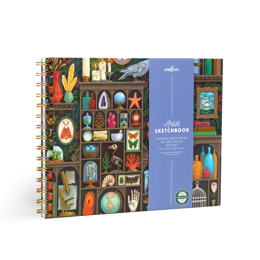 Alchemist’s Cabinet hardcover artist sketchbook by Vasilisa Romanenko with spiral binding and illustrated natural history cabinet featuring plants, insects, crystals, shells, and curiosities.