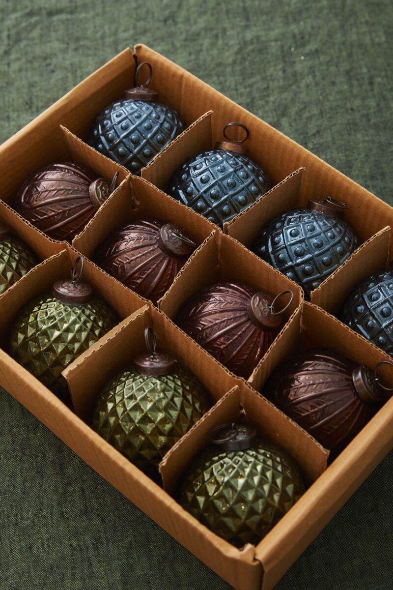 Boxed set of 12 Angelica glass Christmas ornaments in assorted blue, green, gold, bronze and smoky jewel tones.