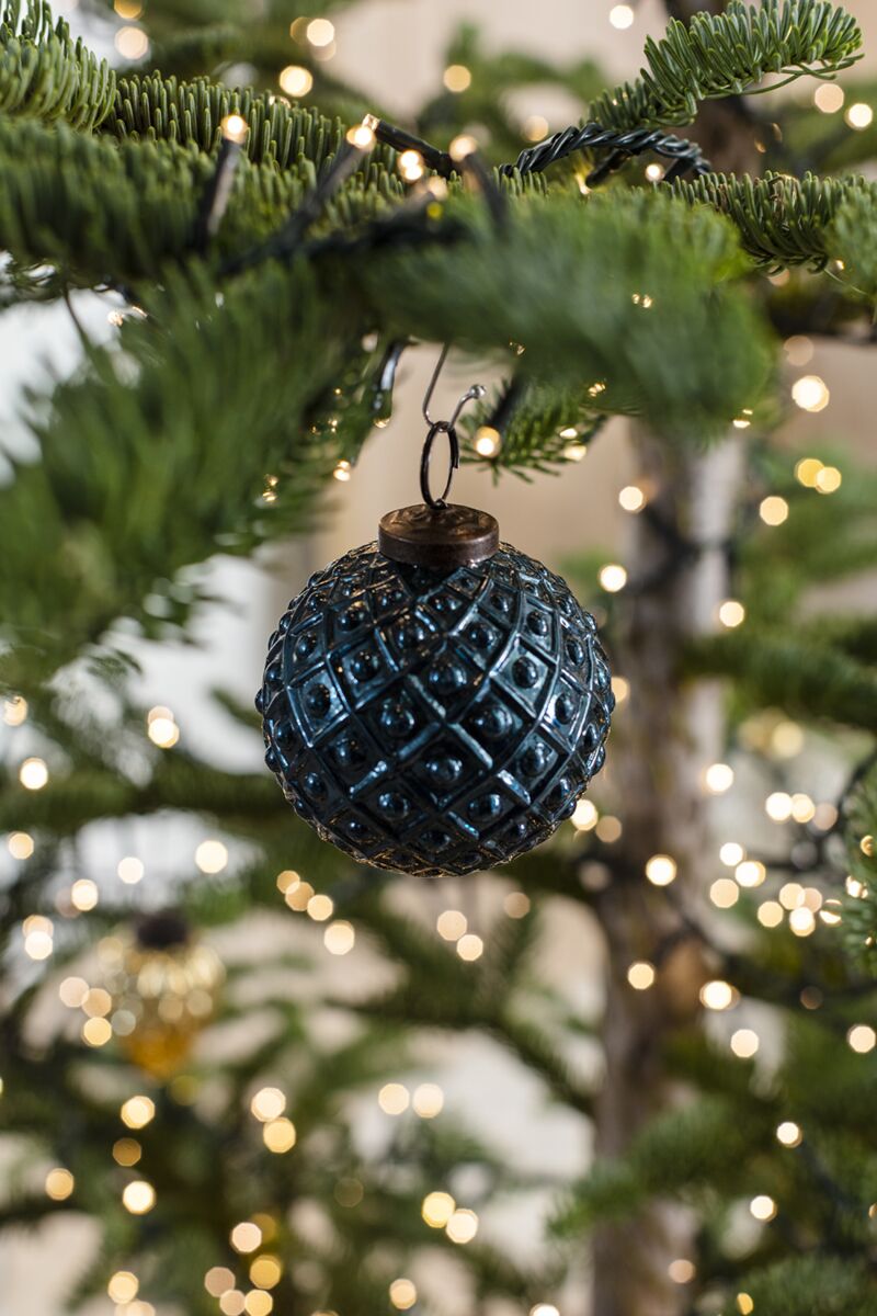 Jewel-toned Angelica glass Christmas ornament hanging from evergreen branches.