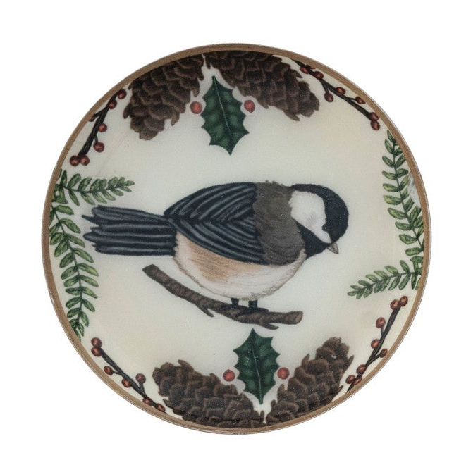 Round enameled metal trinket dish with bird and botanical illustration and gold-toned edge.