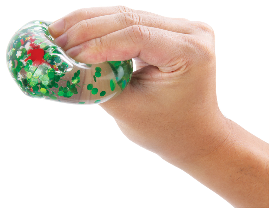 Hand holding a Christmas Qube with green, colorful confetti inside.