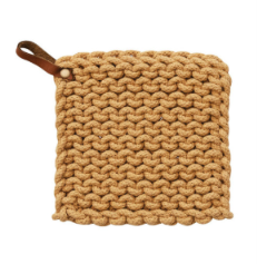 A square, cotton crocheted pot holder in the color mustard with a small brown leather pull tab.