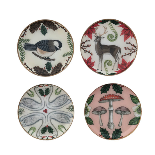 Four round enameled metal botanical trinket dishes with Bird, Deer, Mushroom, and Swan illustrations and gold-toned edges.