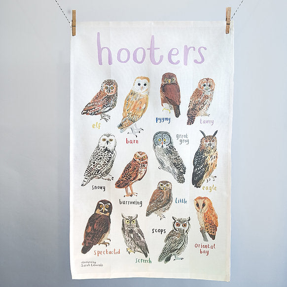 Tea towel with illustrations of owls and text on a white background