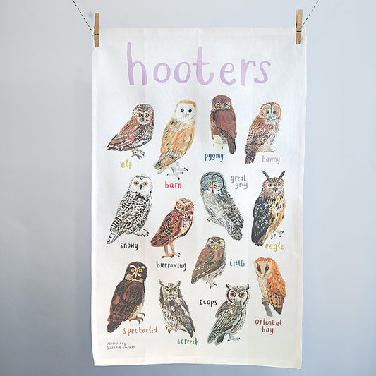 Tea towel with illustrations of owls and text on a white background
