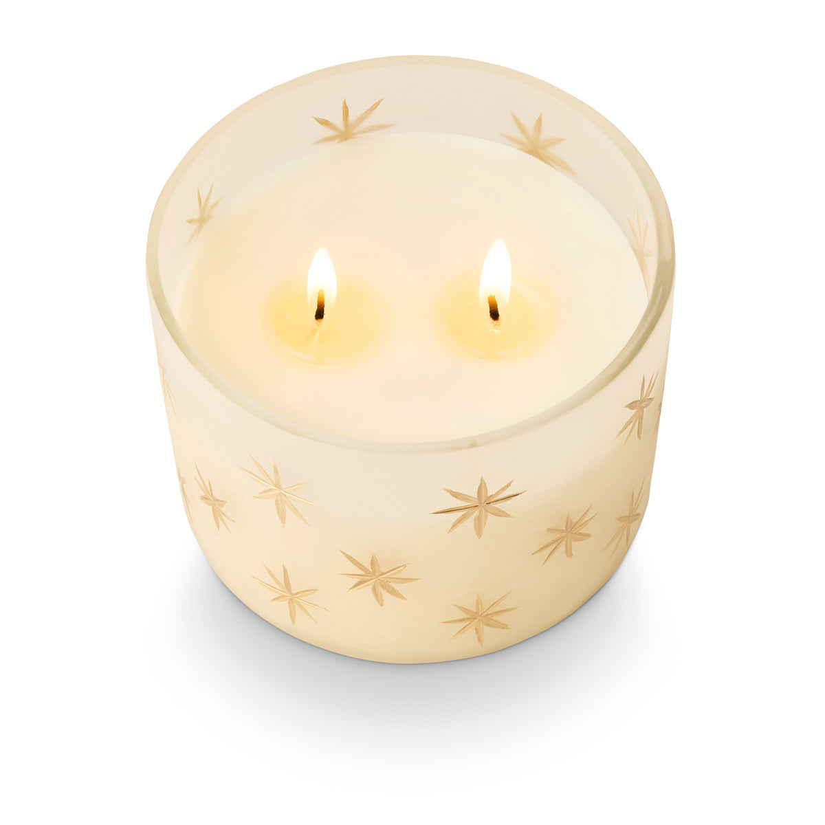 Illume Winter White two-wick candle in frosted glass with delicate gold stars and glowing candlelight.