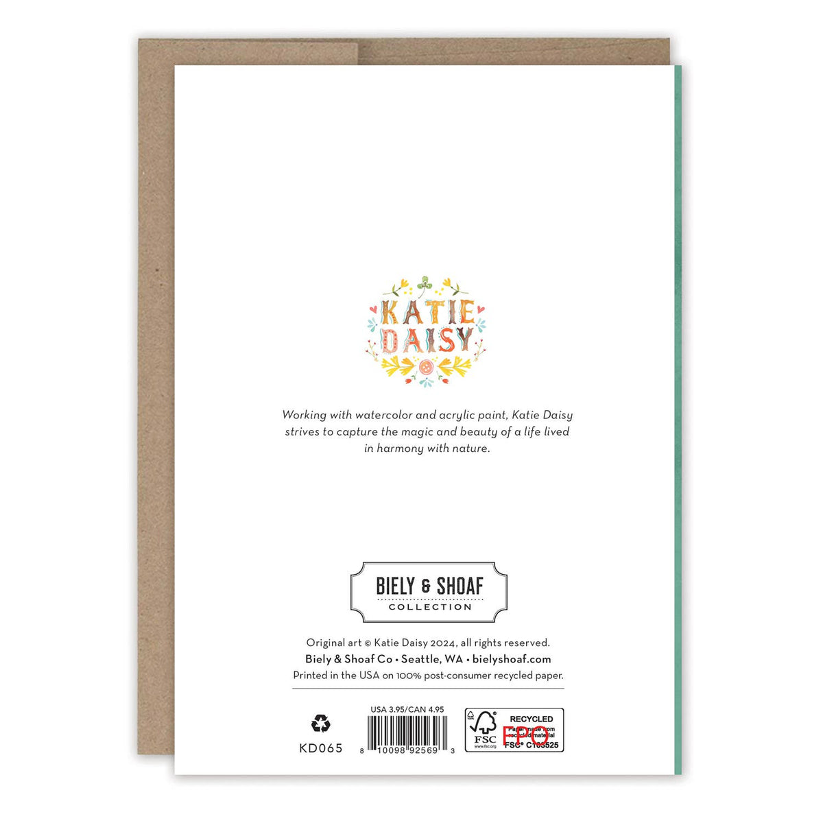 The back of a Katie Daisy Biely & Shoaf Collection art print card, showing the artist's logo, description, barcode, and recycling information, displayed with a brown kraft envelope on a white background.
